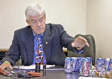 Tom Stafford, vice chancellor for student affairs, reaches out to examine contraband from last Saturday's football game. Stafford insisted on dumping the contraband from the bag to see what students attempted to bring into the stadium with them.