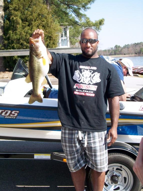 Toney Baker, a halfback on the football team, shows off the eight-pound bass he caught on Lake Wheeler March 22