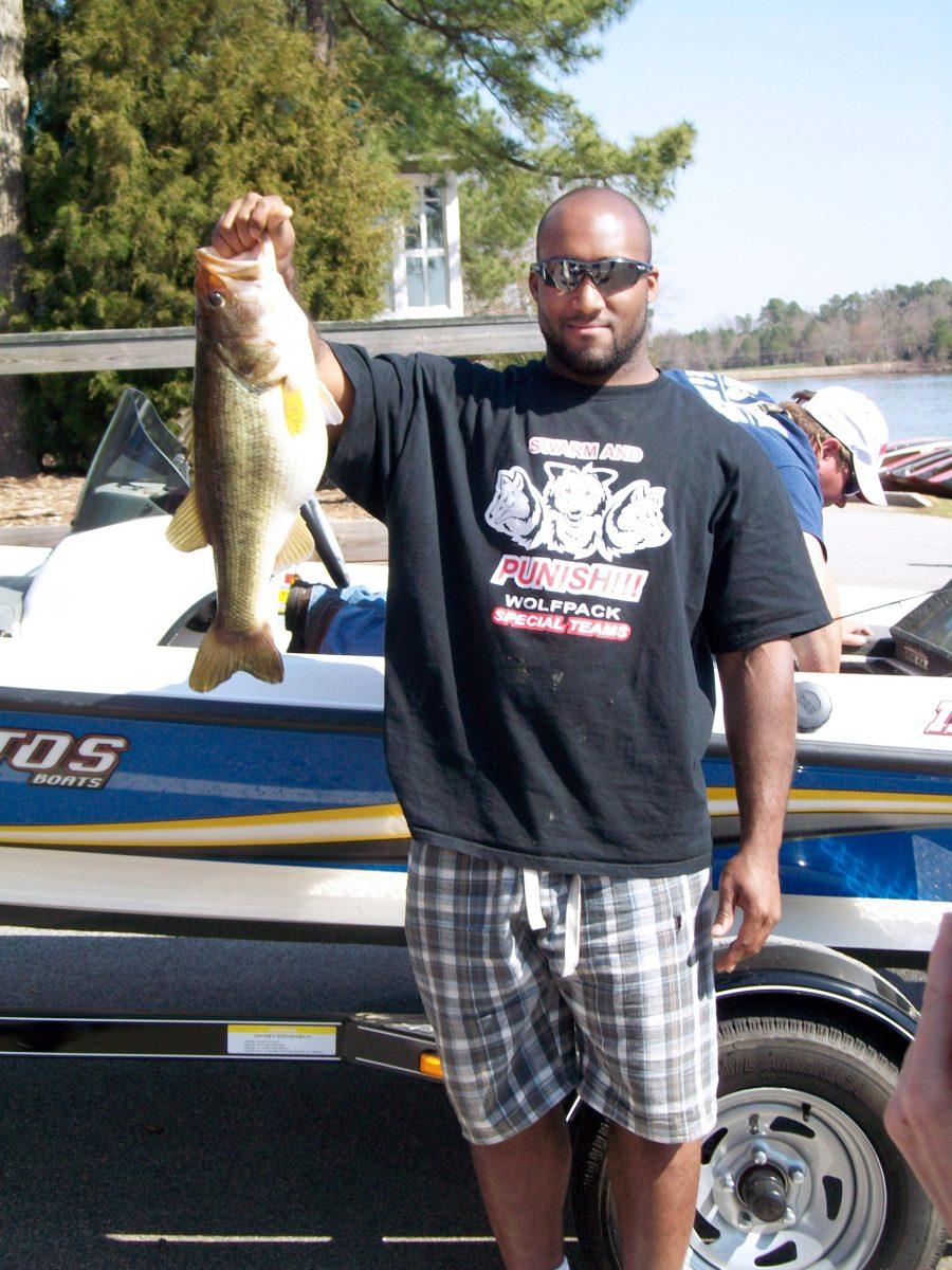 Toney Baker, a halfback on the football team, shows off the eight-pound bass he caught on Lake Wheeler March 22