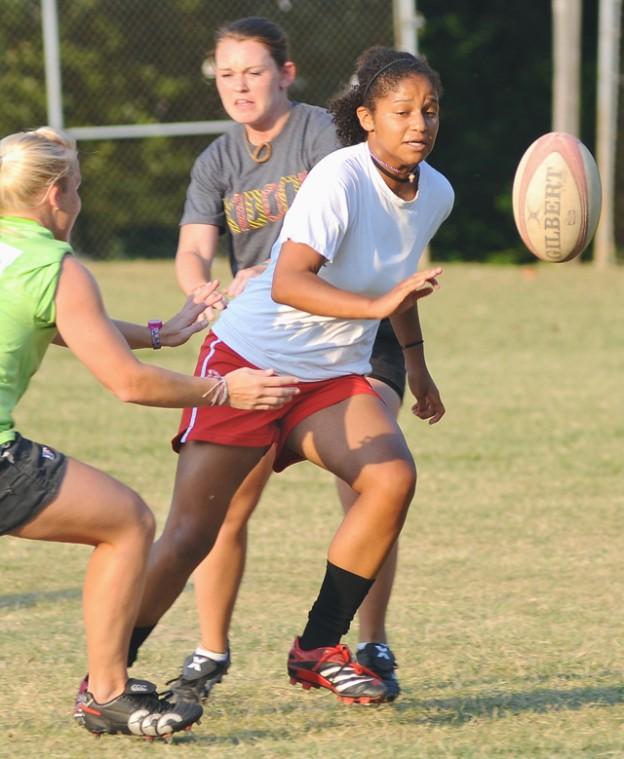 Praticing rugby, Raven Jones, a senior in civil engineering, tries to pull away from Ashleigh Davis, an alumna, and Erin Yow, a senior in agriculture engineering. The Women's Rugby Club went down to Wilmington for a tournament last Saturday, July 4, and has another one in Raleigh on July 18. "We definitely went from being a recreational, 'come out, hang out and meet friends' group to a more serious, devoted group that competes against teams like Carolina and ECU," Davis said. Photo by