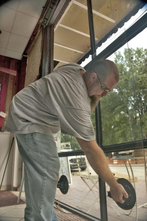 Brian Reed, of Binswanger Glass, puts the final touches on the new glass awning for Melvins' and Five-O-Clock Sports Bar. The renovations, which are part of the plan to draw in more consumers to the area, should be completed within the week. Photo by Jordan Moore