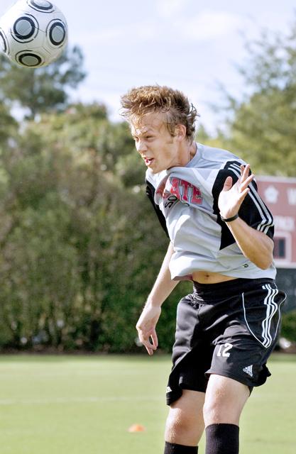 At soccer practice at the Method Road soccer fields, junior defender Tyler Lassiter works on practicing drills with the help of teammates on the men's soccer team. Photo by Amanda Karst