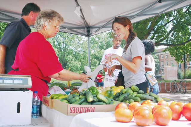Heidi Garrett, a junior in human biology, picks out some vegetables at the Campus Farmers Market on her way back from classes. &#8220;It&#8217;s really convenient being on campus, I can just stop by and pick up some fresh stuff .&#8221; Wise Farms will be on campus in the Brickyard every Wednesday until Nov. 18. Photo by Sarah Tudor