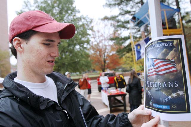 Helping show support for our veterans, Matthew Walker, a sophomore in communication and member of the Kappa Alpha Order at N.C. State, posts a sign promoting Veterans Day on the fraternity's hot dog booth out in the Brickyard. The money raised by Kappa Alpha at its booth is going towards the Wounded Warriors Project and the Honor Flight Network. "We felt it was the right thing to do, to raise money and help out people who allow us to live the lifestyle we do," Walker said. Photo by Nick Toptine
