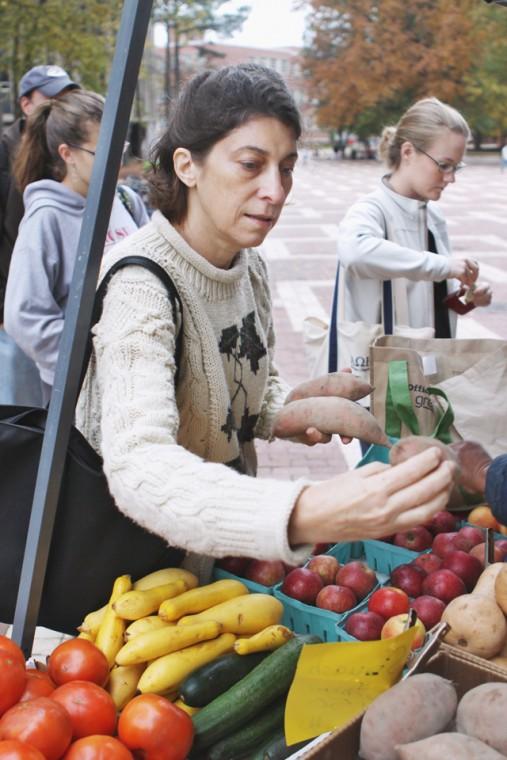 Rose Caldwell, a senior in horticulture science, picks out sweet potatoes from Wise Farms at the last Farmers Market of the fall semester on Wednesday, Nov. 18th, 2009. "It's awesome," Caldwell explained. "It's a wonderful opportunity to support the local economy and eat fresh and wonderful food." The weather kept a couple vendors away but Wise Farms was out selling produce and Mae Farms was offering dairy and meat products. Photo by Amanda Wilkins