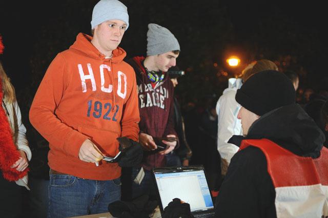 Outside Reynolds Coliseum, Jonathan Walker, a junior in political science, checks in with Jordan Hammond, a freshman in history, to Campout Saturday. Due to computer issues, some groups had to re-register because their group was deleted. "I got a bunch of hand warmers, I just made some chili and I'm going to huddle up," Walker said of the oncoming cold night. Photo by Luis Zapata