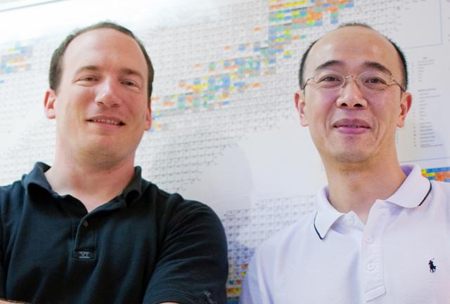 Associate professors Steven Shannon, in nuclear engineering, and Hong Luo, in mechanical engienering, pose for an environmental portrait behind a chart of nuclides in Burlington Labs Wednesday. Shannon and Luo were part of a team awarded a combined $1.5 million grant from the Department of Energy. Photo by Amanda Karst