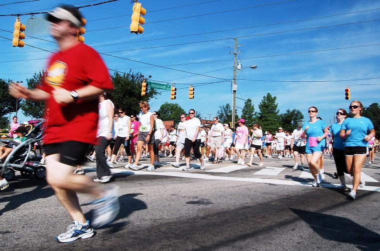 Runners and walkers in the 5K open run event at the 2009 Susan G. Komen Race for the Cure run through the intersection of Hillsborough and Gorman/Faircloth streets Saturday.