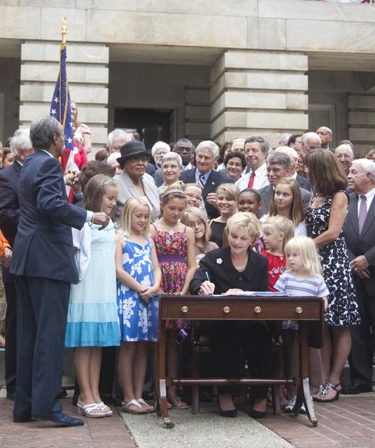 Gov. Perdue signs her signature at the budget bill signing ceremony on the East Lawn of the North Carolina State Capitol Building Wednesday.