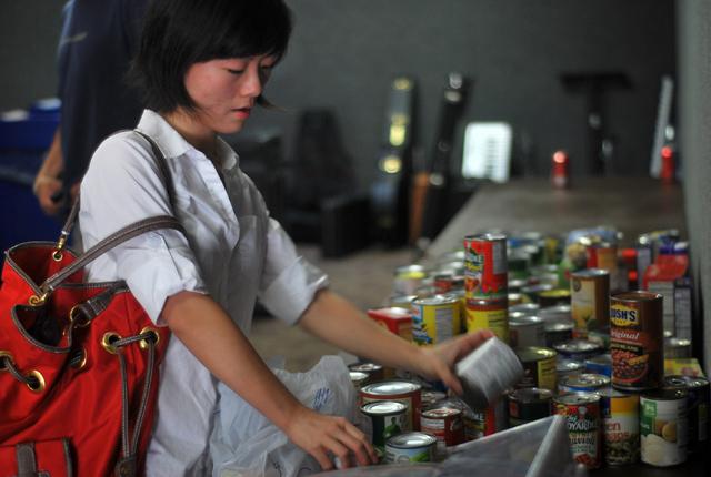 Ting Ting Ji, a sophomore in statistics, donates various cans for the Rock Can Roll concert in Witherspoon Student Cinema. All canned goods were sent to help the Food Bank of Central and Eastern N.C. Photo by Kali Rogers
