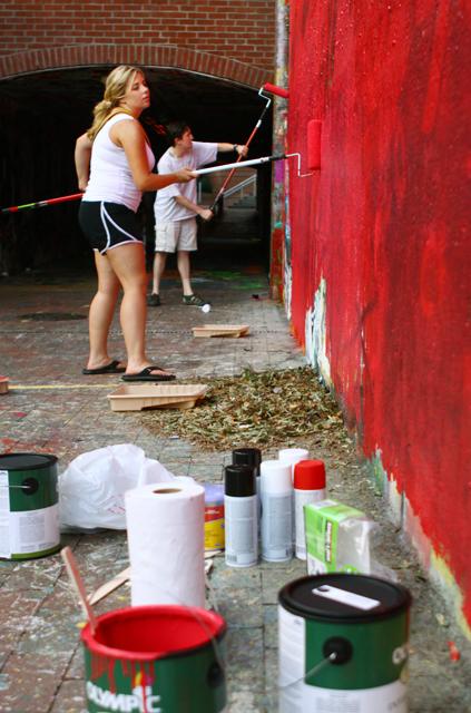 Jen Parks, a 2010 alumna in microbiology, and Brett Pedersen, a 2005 alumnus in business management, paint the wall at the entrance to the Free Expression Tunnel to advertise The Wolf Web on Monday. &#8220;I got dragged in [to The Wolf Web] a couple of years ago and haven&#8217;t left since,&#8221; Parks said. &#8220;It&#8217;s a good source of information and a constant source of laughter.&#8221; Photo by Marisa Akers