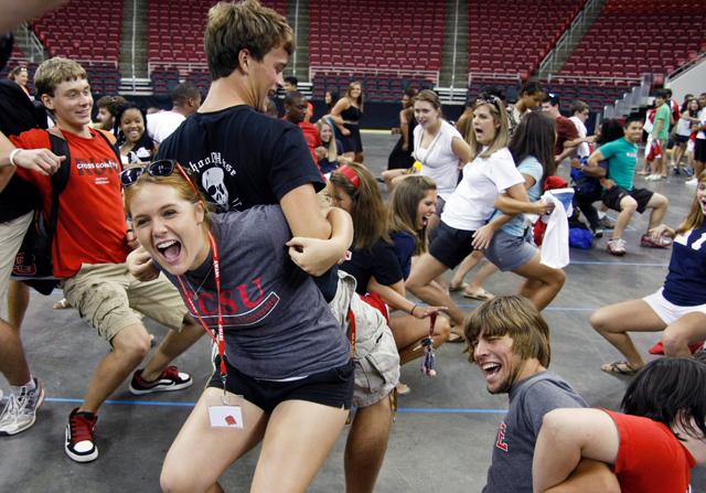 Katie Liguori, a freshman in First Year College, dances back-to-back with a fellow freshman at Convocation in the RBC Center Monday, Aug. 16.