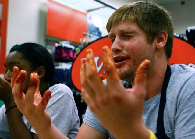 Justin Platis, a junior in industrial engineering, grimaces after winning an eating contest in Target during the Late Night Run Aug. 15. The 10 buffalo wings for each contestant, supplied by Wing Zone, were flavored with Nuclear sauce, the hottest option offered. "They were super, nuclear-hot, un-Godly, treacherous wings," Platis said. "I want to thank God, my mom, my girlfriend...and Russell Wilson."