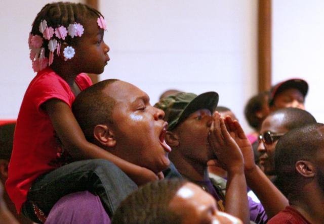 Keonta Wallace, a senior in mathematics, holds his daughter, Aisjan Wallace, on his shoulders and cheers for the performers at Back 2 School Jam.