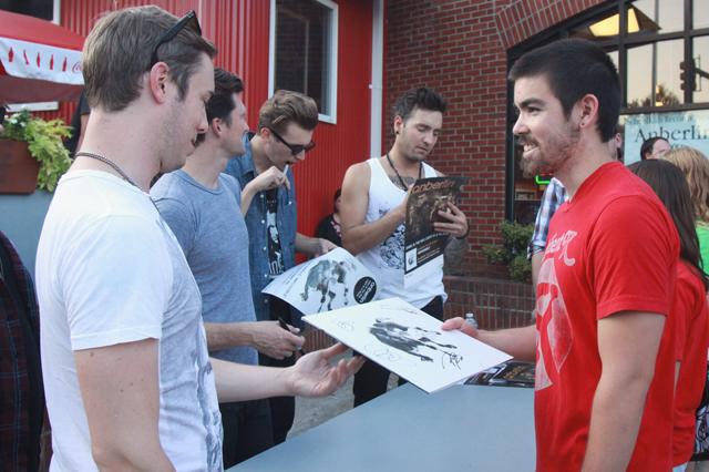 TJ Louie, a junior in industrial engineering, reaches for his signed copy of Anberlin's new record, "Dark is the Way, Light is a Place". Louie had been a fan of the band for four years, but had never seen them perform live until their free show at Schoolkids Records. "It was the most amazing event around campus this year," Louie said. "It was cool to meet them. They're down to earth." Photo by Marisa Akers