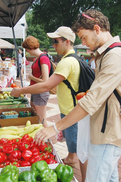 Vincent Feucht, a senior in English, shops for produce at the Campus Farmer&#8217;s Market, along with Abby Rife, a junior in animal science, and Adam Taylor, a sophomore in business administration and international studies. Feucht purchased food such as tomatoes, peppers, grapes and peanut butter. &#8220;Understanding the connection with where your food comes from is important,&#8221; Feucht said. &#8220;After working on a farm this summer, I can appreciate how they grow the food.&#8221; Photo by Megan Farrell