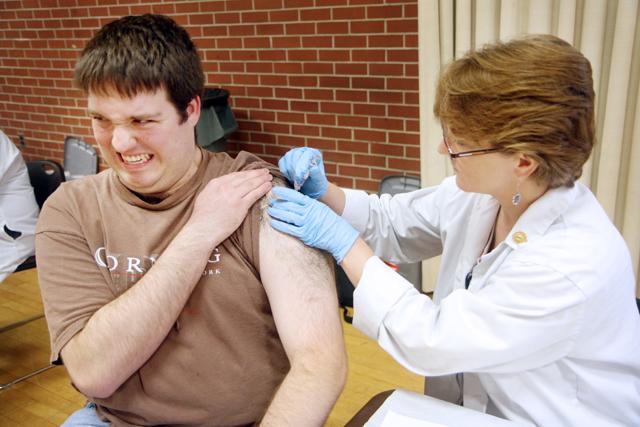 Joseph Magliocca, a fifth-year student in biochemistry, cringes as he receives the H1N1 vaccine injection from Registered Nurse Monteen Lerew. Photo by Peggy Boone