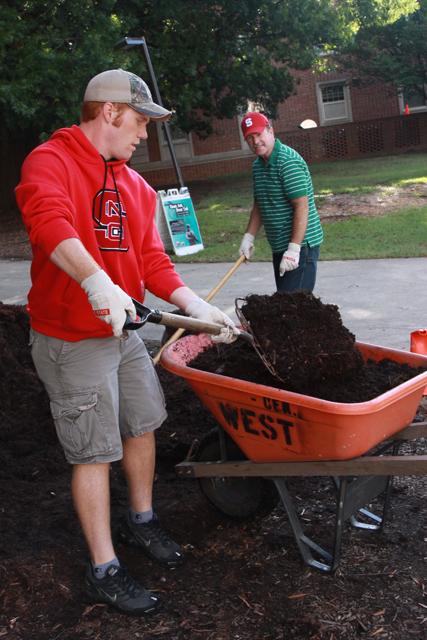 Parks Harrington, a freshman in turfgrass management, shovels mulch with his dad, Randy Harrington, from Taylorsville, N.C. "I think it's a good experience," Parks said. "It's a good way to spend time with family, instead of going home to see them."