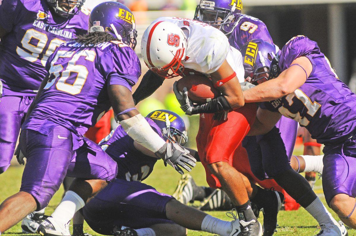 Redshirt freshman halfback Dean Haynes, is tackled by a horde of ECU players during the Saturday match-up in Greenville, N.C. Haynes had 33 yards of passing from 4 throws with 13 being the lostest and 36 yards from rushing. N.C. State lost to ECU in overtime, 33 - 27.