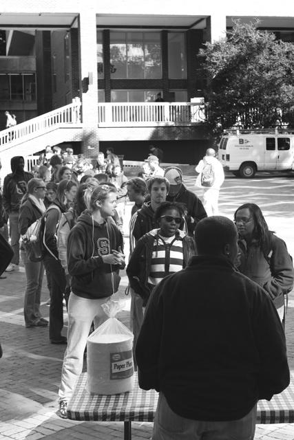 A line of students wrap around Brickyard Bubble awaiting the signal to grab pizza at the Wear Red, Get Fed event Monday. With more than 1,000 students expected to show up each day of the event, food tends to run out fast, members of the Homecoming Committee said. Margo Sauter, a senior in mechanical engineering, Latreese Denson, a senior in marine science and Khalia Braswell, a junior in computer science, are the first ones in line to get pizza from Dominoes. Photo by Danielle Neujahrid