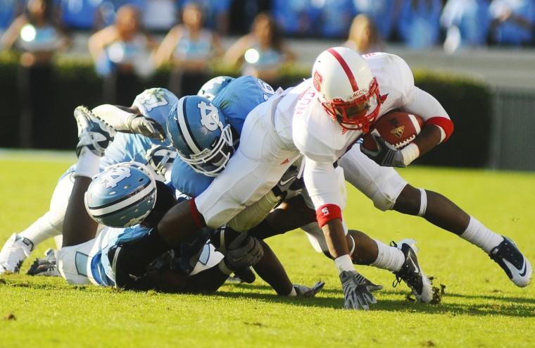 Sophomore James Washington fights for extra yardage against UNC defenders. N.C. State won 29-25 at Kenan Stadium on Saturday.