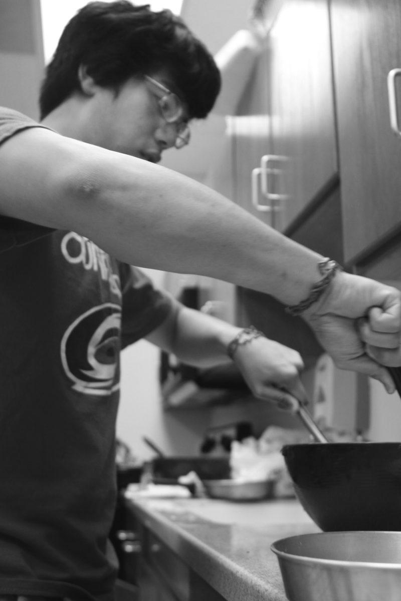 Bryant Budi, a sophomore in electrical and computer engineering, stirs chocolate cake batter during the Cooking with Google session in the Honors Village Monday night. Google representatives got together with honors students to bake, fry and sautee new dishes. One of the new dishes the group created consisted of an apple medley, sauteed with cinnamon, which they called &#8220;Apple Chutney.&#8221; Photo by Lee Daniello