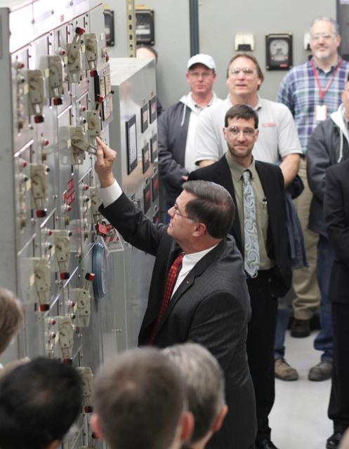 Charlie Leffler, vice chancellor for finance and business, pulls the lever to "shut down" the Cates Avenue steam plant Friday. Photo by Lee Daniello.
