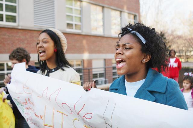 N.C. State students Latika Williams and Salena Wright march across campus with CSLEPS during the 2010 MLK Service Challenge. Chants and signs among the group demanded an end to hunger. &#8220;MLK was down for equality for all,&#8221; said Wright. &#8220;He was a voice for people who couldn&#8217;t speak for themselves.&#8221; Photo by Marisa Akers.