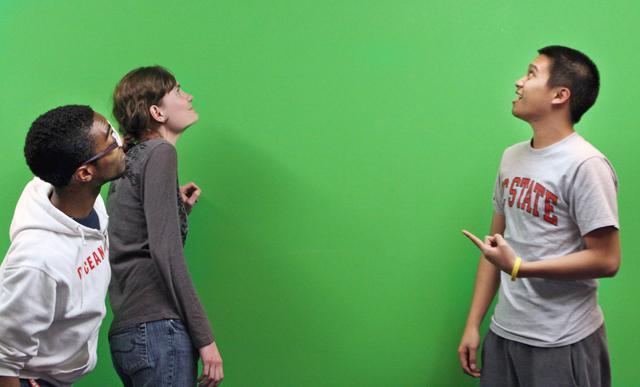 Kenneth Howell Jr., a sophomore in international studies, Ken Farnaso, a junior in human biology, and Kathryn Loyd, a freshman in chemistry, play around in the room with the green screen, which is actually just a green painted wall in a closed-off room on the first floor of D.H. Hill Library. &#8220;We were actually in here to study because there were people everywhere else, but we&#8217;ve shot a few videos in here just for fun,&#8221; Farnaso said. Photo by Lee Daniello.