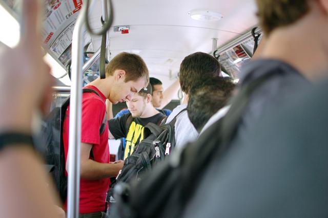 Eric Luibrand, a junior in mechanical engineering, texts a friend on a cramped engineering bus Tuesday evening, March 22, 2011. The engineering route on the Wolfline has historically been extremely crowded during class changes, requiring an extra tripper bus this year. "[the overcrowding] is bad, yeah, Luibrand said. "Especially the 5 p.m. bus that leaves Centennial. I've missed it a number of times because there were too many people." Photo by Jordan Moore.