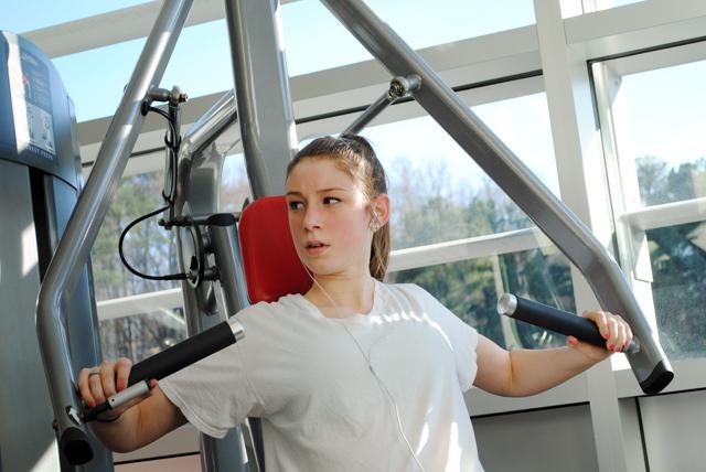 Working out at the Carmichael Recreation Center, Megan May, a freshman in fashion and textile management, works her pectoral muscles. May said that spring break has not really affected her workout schedule, because she is a regular. "I'm a cheerleader, so I usually get a good workout."