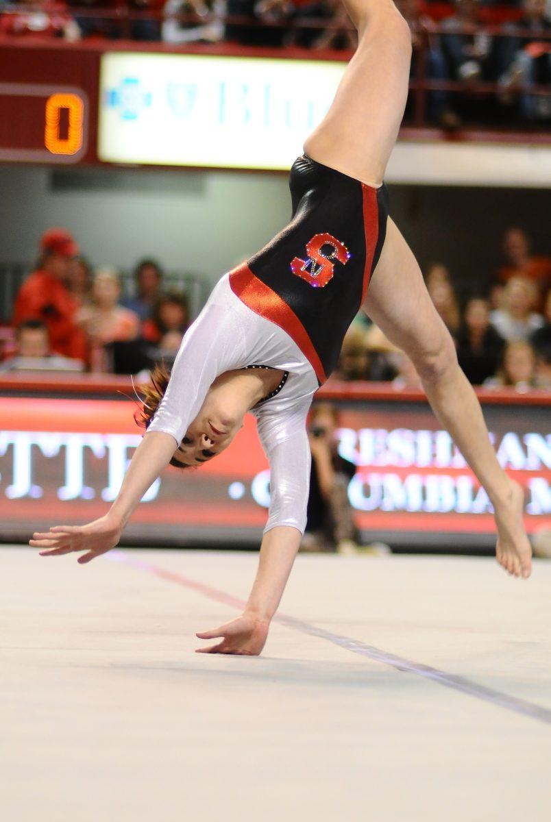 Freshman gymnast Stephanie Ouellette performs in the floor event in Reynolds Coliseum. Photo taken by Luis Zapata.