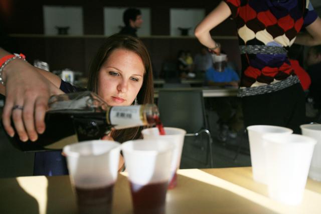Sarah Mazur, a junior in accounting, pours ceremonial grape juice into plastic cups for the Passover Seder April 18. Passover is a Jewish holiday celebrating the exodus from slavery in Egypt. The grape juice was used in place of wine, which is consumed four times throughout the celebration. The four cups of wine at the Passover Seder represent the four promises God made to the Jewish people. Photo by Jordan Moore
