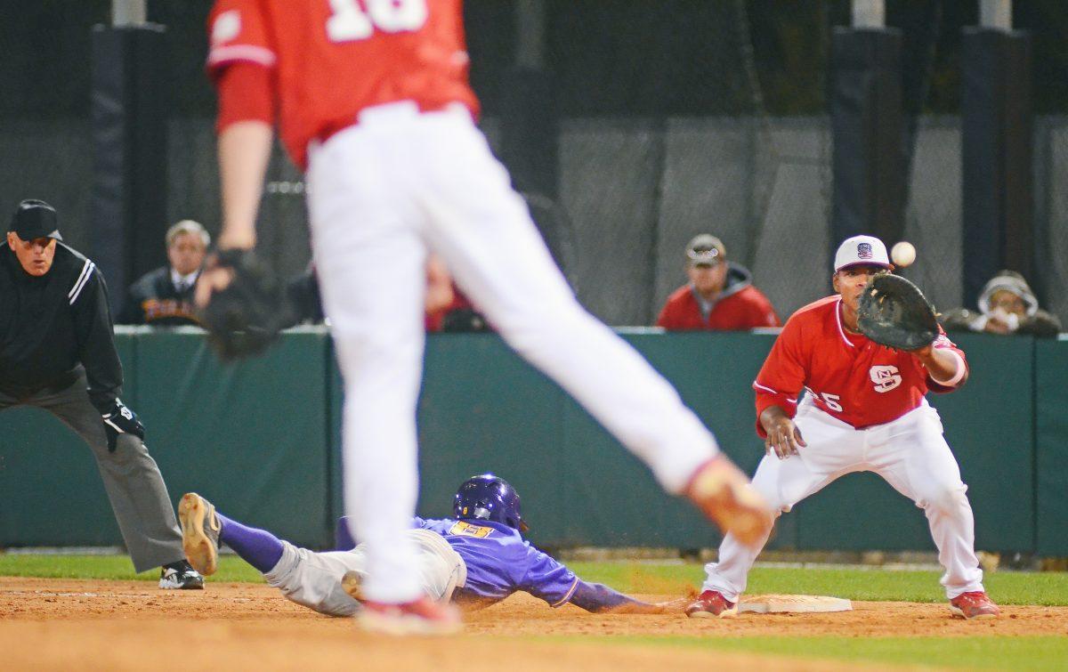 Sophomore relief pitcher Chris Overman attempts to pick off a runner in the Wolfpack's game against ECU on Tuesday. Overman struck out four batters, allowing no runs in 2.1 innings of work, helping State to a 4-2 victory over its in-state rival.