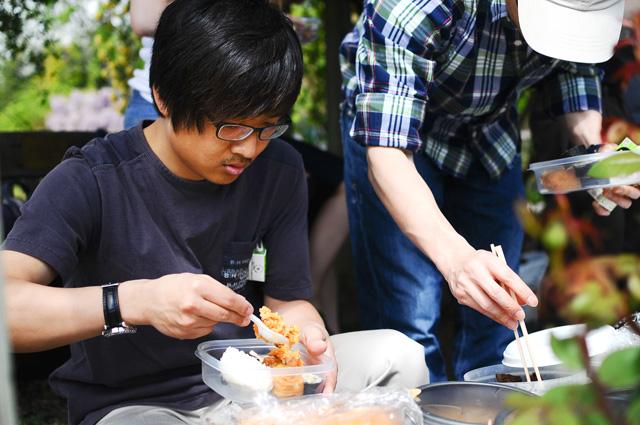 Hoom Seok Kim and Seung Hun, graduate students in electrical enginerring, serve themselves during the Society for the Refinement of Polyvarietal Entertainment's bento picnic in J.C. Raulston Arboretum Sunday afternoon. Kim made kimchi rice, a Korean dish. "I didn't have a ride," Kim said, so he invited his friend Hun to come with him. Photo by Luis Zapata.