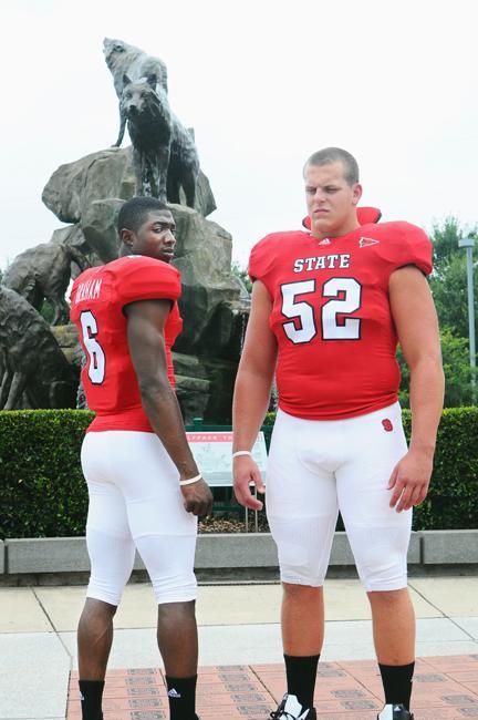 Redshirt senior defensive tackle J.R. Sweezy (52) and senior wide receiver T.J. Graham (6) model the new Wolfpack football jerseys on Tuesday afternoon at the Murphy Center. Photo taken by Brent Kitchen.