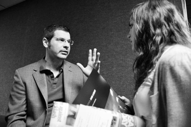 Chris Hondros, Pulitzer Prize nominated war photographer and N.C. State alumnus talks about his experience in Afghanistan with Erica Abed, a sophomore in psychology. Hondros died in Libya on an assignment April 20. Photo by Tim O'Brien.