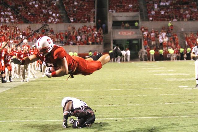 Senior full back Taylor Gentry dives over a Cincinnati defenseman into the endzone, scoring the final touch down for N.C. State, leaving the score 30-7 in the middle of the fourth quarter. Gentry had three receives and convered twentry yards for the game. Photo by Alex Canoutas.