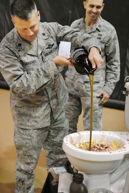 Lt Col Chris Froeschner pours his ingredient into the grog. Cadets brought up infractions on each other, making their arguments in the form of rhyme. If students could not form an adequate rhyme in response, they were required to drink from the pot. October 21, 2011. Photo by Michael Pratt.