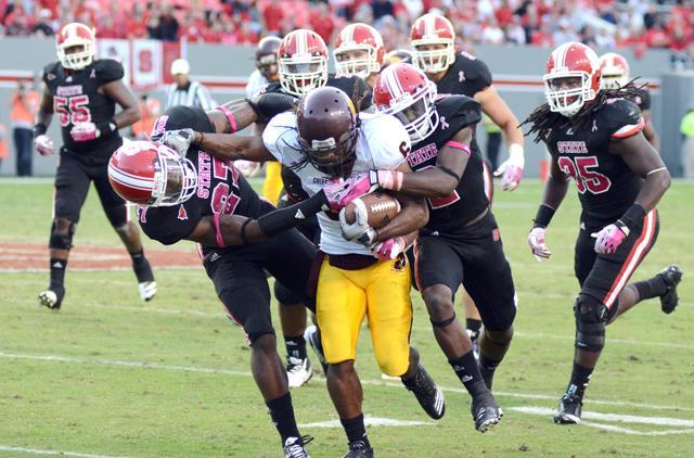 A horde of State defensemen, including redshirt junior safety Earl Wolff and redshirt sophomore cornerback Rashard Smith, take down the Central Michigan player attempting to run the football during the game on Saturday, Oct. 8 in Carter-Finley Stadium. Photo by John Joyner.