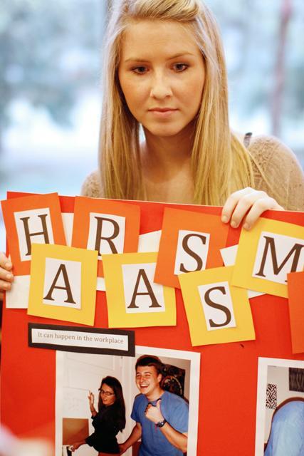 Abigail Howe, senior in communications media shares a poster about the dangers of sexual harassment during the Sexual Health and Information fair held in Caldwell Hall. Photo by Oliver Sholder