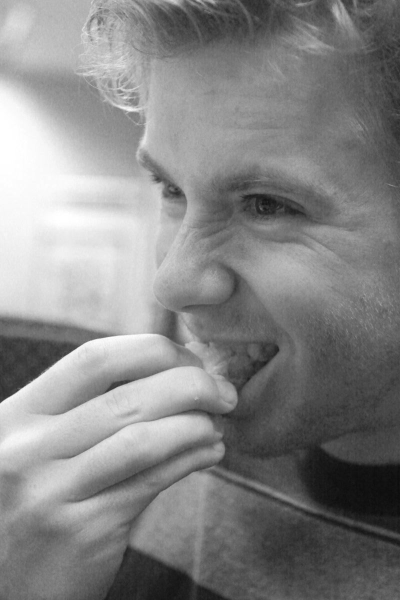 Kyle Jones, junior in nutrition science, eats a slice of french cheese, during a cheese tasting event that was held by the French Club, Wed. at Withers Hall. Photo by Thomas Obarowski