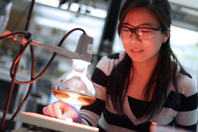 Ying Liu, a graduate student in chemical and biomolecular engineering, creates a 3-D object out of a 2-D pattern using printed lines and heat in Engineering Building I on Centennial Campus on Tuesday, Nov. 15, 2011. The objects were formed by printing lines on specially cut, pre-stressed Shrinky Dinks, which were then heated using a common heat lamp. Photo by Tyler Andrews