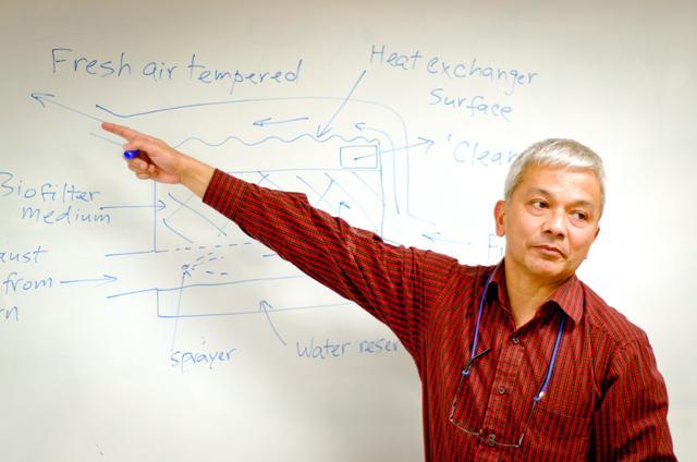 Dr. Sanjay Shah, associate professor in the Department of Biological and Agricultural Engineering, explains a system he helped developed to reduce harmful waste gases and energy consumption on farms. The system uses a biofilter, which uses bacteria to clean the air, and a heat exchanger to recover the heat that is produced by the bacteria. Photo by John Joyner.