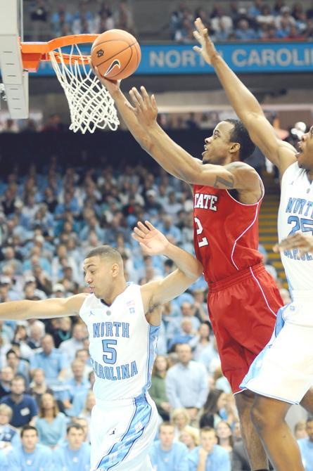 Freshman guard Lorenzo Brown attempts a layup over North Carolina's Kendall Marshall while John Henson attempts to block the shot during the first half of the Pack's game at the Dean E. Smith Center Saturday, Jan. 29, 2011. Brown had a career high 20 points, but State lost to the Tar Heels 84-64. Photo by Brent Kitchen