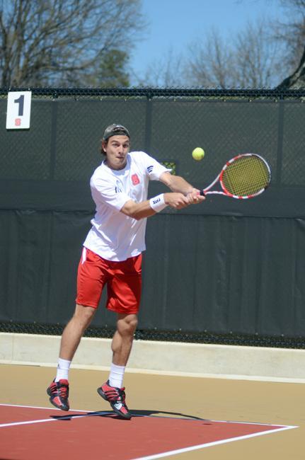 Returning the ball, sophomore Sean Weber leaps in the air. Weber and his partner, Julian Sullivan, won their doubles match, 8-4, against Binghamton in the Wolfpack's win Saturday, March 10. Photo by Ryan Parry.