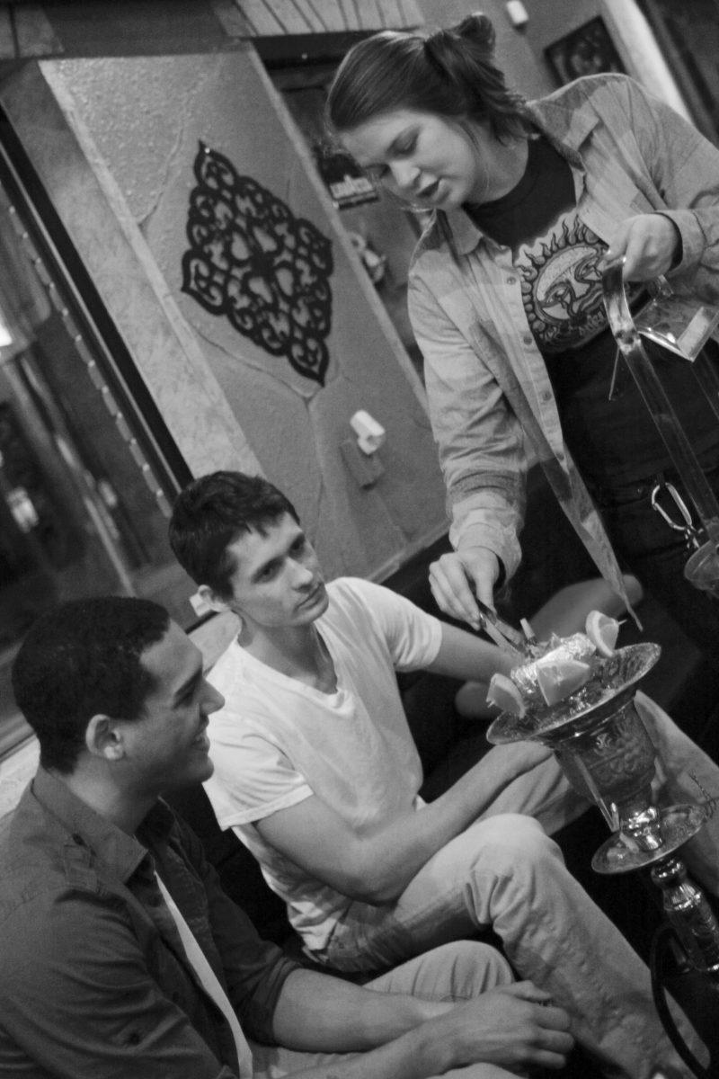 Sophomore in environmental science Elias Orbon and his friend Bryce Charette, a sophomore in psychology, chat with barista Hope Levinson as she places fresh coals on their hookah at Nara Lounge. "We were looking for a place with some class," Orbon said. "We looked at other hookah lounges on Hillsborough street, found this place, and that was it." Photo by Brett Morris.