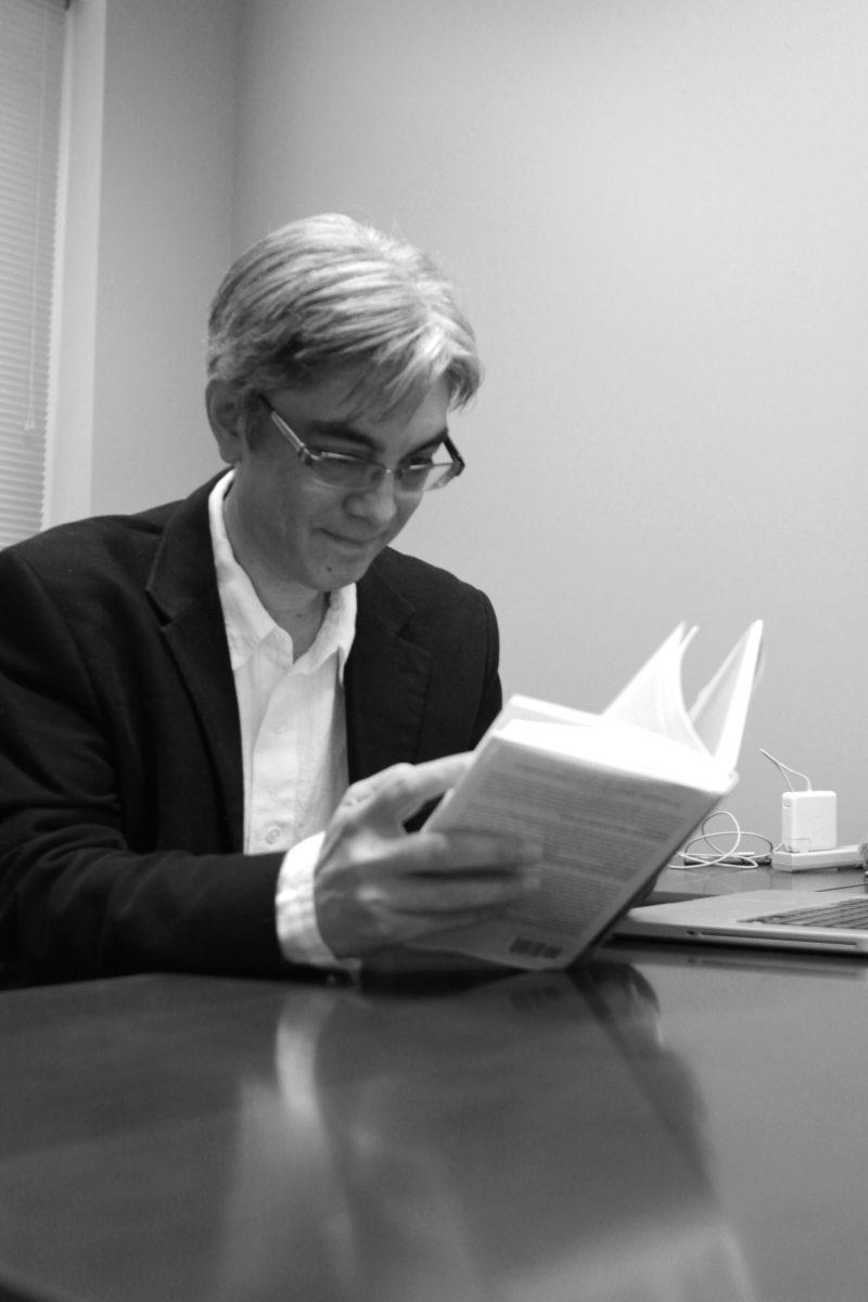 Photo by Joannah Irvin. Robert St. Amant, associate professor in the computer science department, reads a passage from his lasted publication "Computing for Ordinary Mortals" on Jan. 14. "I wanted people to understand that computers are not just hardware and software," Amant said "I wanted to show the other areas like artificial intelligence and what that has to offer.' Ament also said that the entire process took him about 3 years to complete because he only worked on it on the weekends.