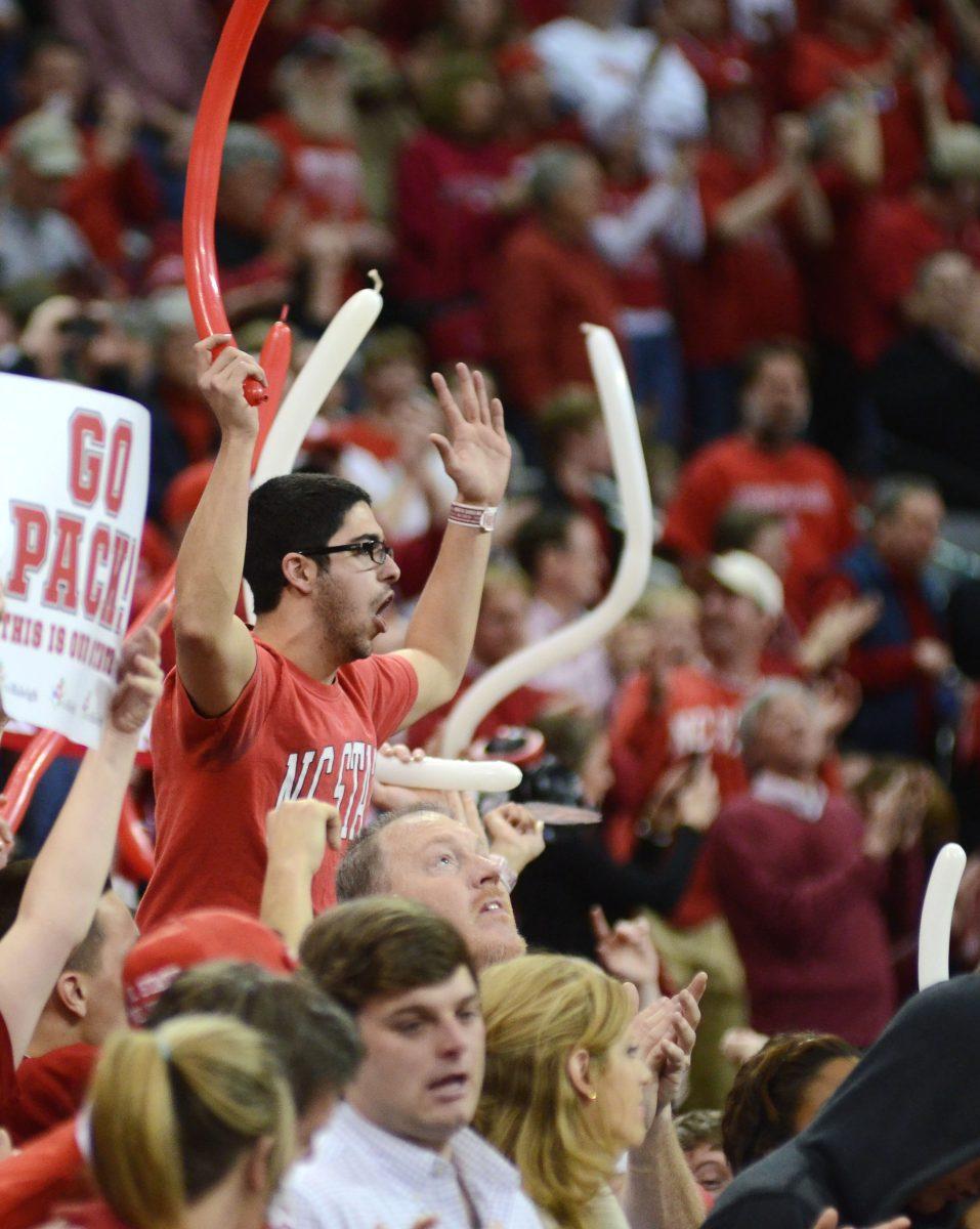 Phiroze Divecha, a senior in mechanical engineering, is raised above the student section by his friends during the first half of the North Carolina game Saturday, Jan. 26, 2013. The Wolfpack defeated the Tar Heels 91-83 for the first time in six years at the PNC Arena. "We got in trouble by the security staff for it," said Divecha. Photo by Ryan Parry.