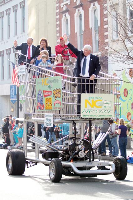 Photo by Joannah Irvin. Steve Troxler, agriculture commissioner, and sen. Brent Johnson ride in a motorized shopping cart during the inauguration parade in downtown Raleigh on Saturday Jan 12.